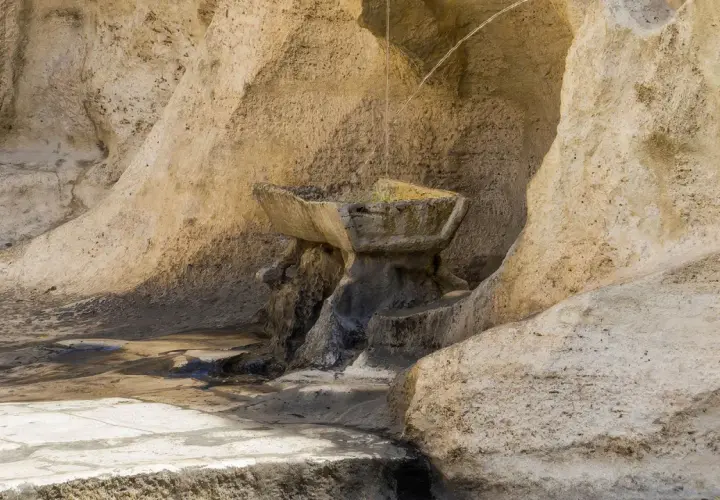 Antica fontana degli innamorati a Roma, scolpita nella roccia, con acqua che scorre.