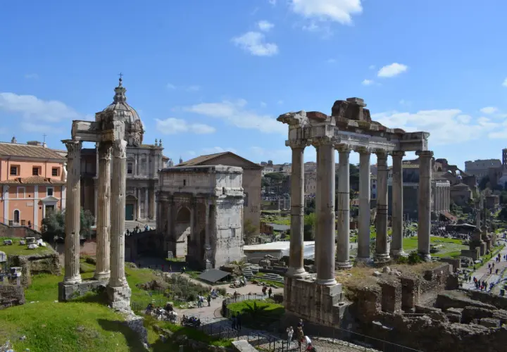 Le rovine del Foro Romano, con colonne imponenti e un arco trionfale, sotto un cielo azzurro. Un assaggio di Roma 72h.