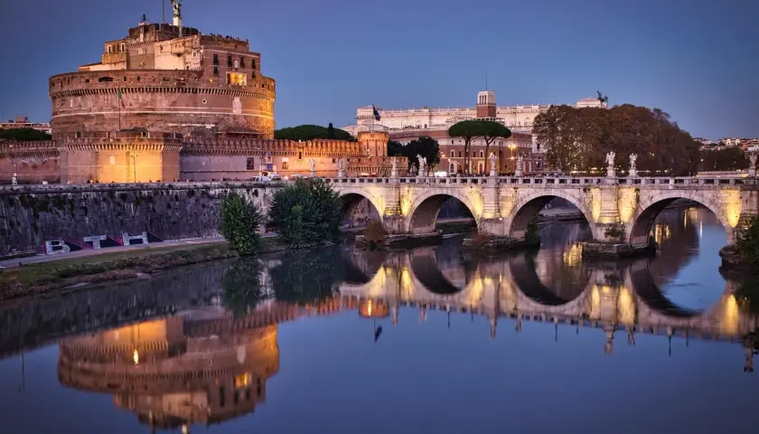Castel Sant'Angelo illuminato di sera, riflesso sul Tevere. Un'idea romantica per cosa fare a San Valentino a Roma.