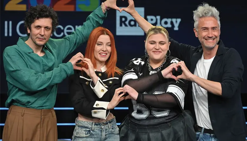 Artisti sorridono formando cuori con le mani, pronti per il concerto Roma 1 Maggio.