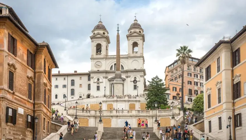 Scalinata di Trinità dei Monti, un must per chi cerca cosa vedere a Roma in una settimana. Turisti salgono i gradini verso la chiesa con obelisco.