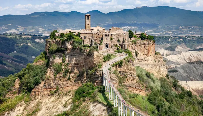 Civita di Bagnoregio, un borgo arroccato su una rupe, si trova in provincia di Viterbo. La sua bellezza è unica, raggiungibile solo tramite un lungo ponte pedonale.