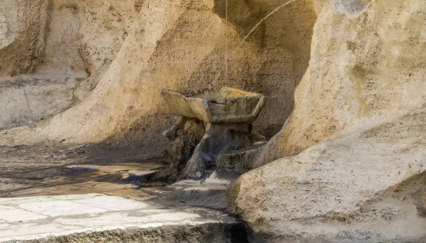 Antica fontana degli innamorati a Roma, scolpita nella roccia, con acqua che scorre.