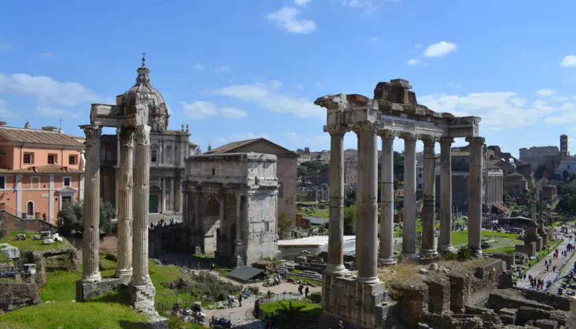 Le rovine del Foro Romano, con colonne imponenti e un arco trionfale, sotto un cielo azzurro. Un assaggio di Roma 72h.