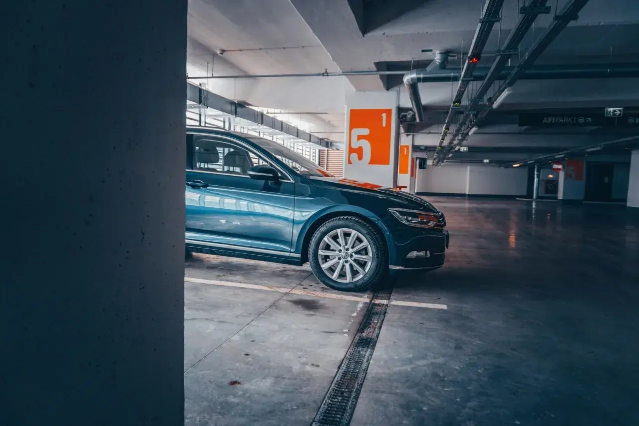 Auto blu parcheggiata nel parcheggio della metro Cipro, con numeri arancioni sulle colonne.