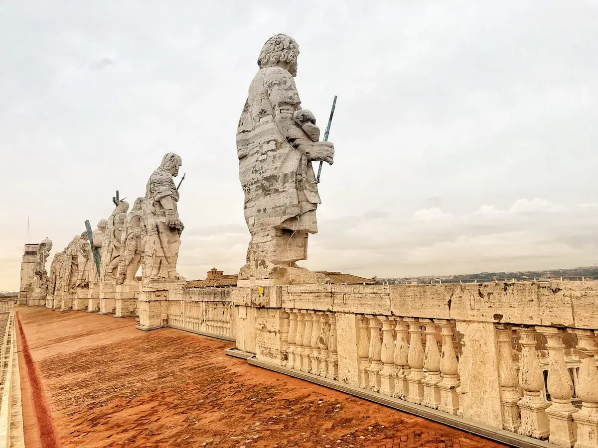 Statue di apostoli sul tetto di San Pietro, un'emozionante passeggiata da Termini a San Pietro a piedi.