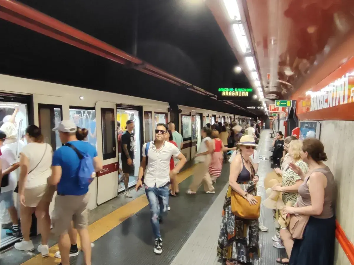 Persone in attesa del treno alla stazione Barberini di Roma.