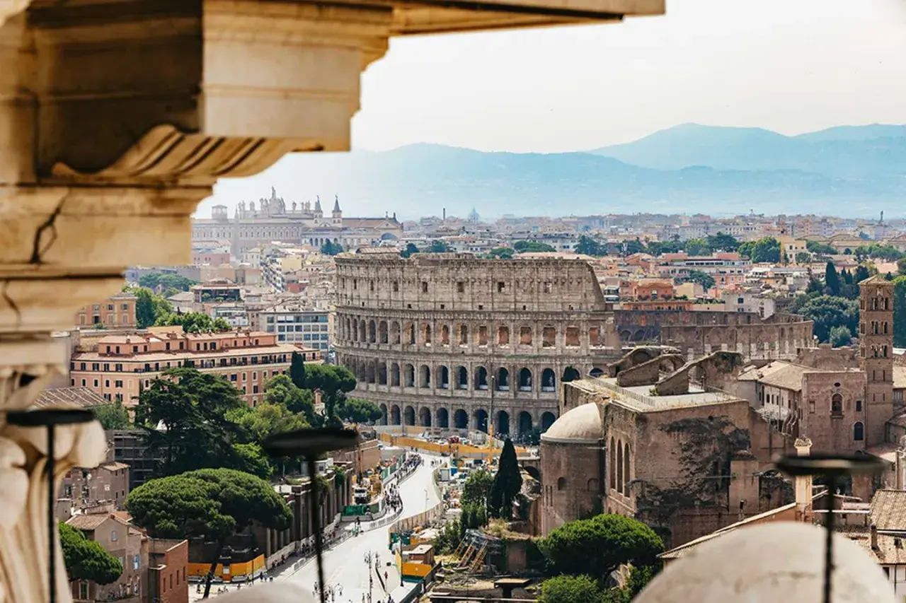 Vista panoramica di Roma con il Colosseo in primo piano, perfetta per un weekend in metro tra storia e bellezza.