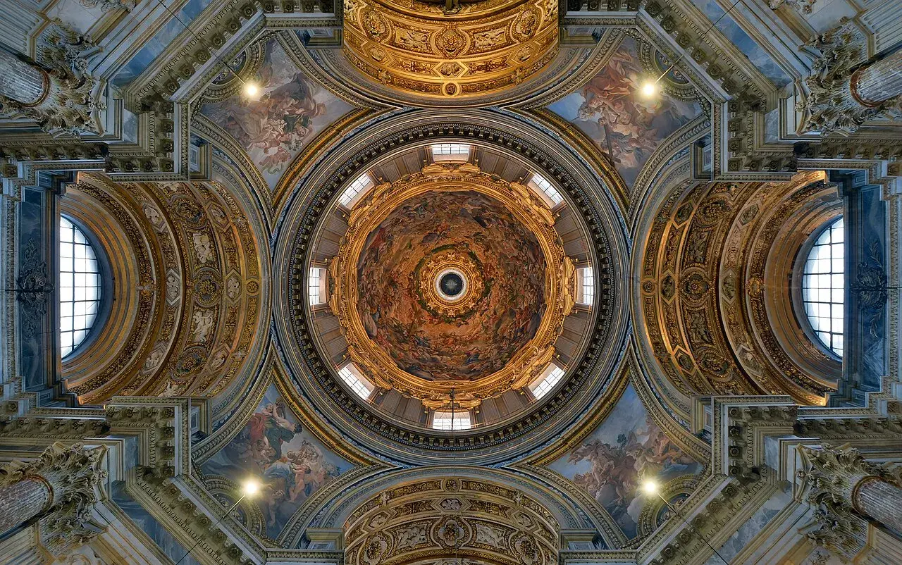 Soffitto affrescato di una delle magnifiche chiese barocche di Roma, con cupola centrale e decorazioni dorate.