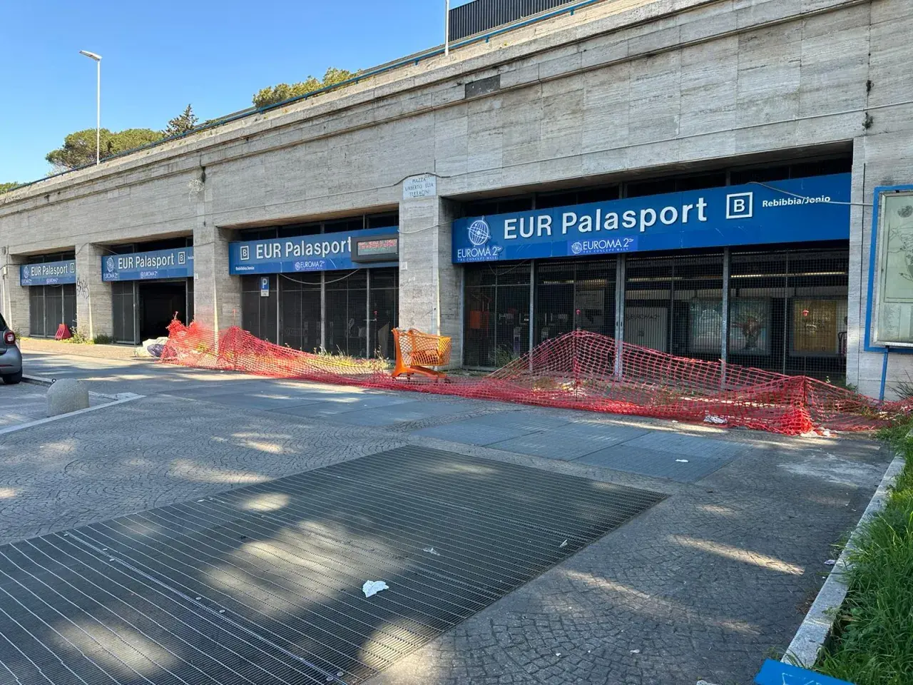 Roma, parcheggio gratuito metro EUR Palasport. Recinzione arancione davanti all'ingresso della metro.