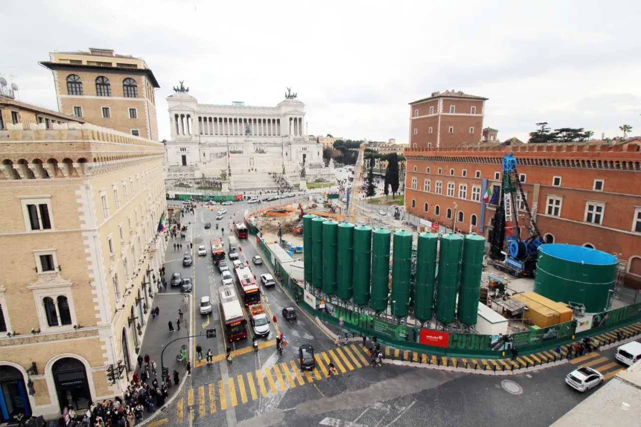 Vista aerea di Roma con il Vittoriano sullo sfondo e lavori in corso. Per capire come arrivare a Piazza Venezia, osserva il traffico e i palazzi storici.