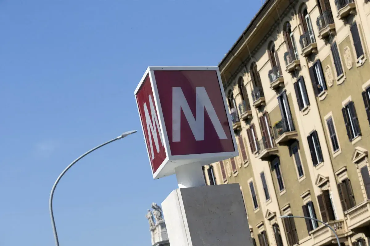 Segnale della metro con la "M" rossa su sfondo bianco, vicino a un palazzo storico. Baldo degli Ubaldi metro.