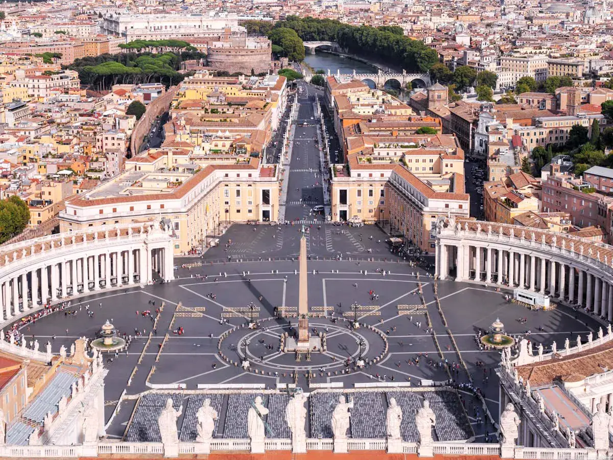 Vista aerea di Piazza San Pietro a Roma, con il colonnato, l'obelisco e la folla di fedeli.