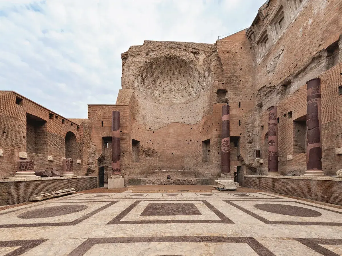 Interno del **tempio di Venere a Roma**, con colonne imponenti, mosaici sul pavimento e un soffitto a volta parzialmente crollato.