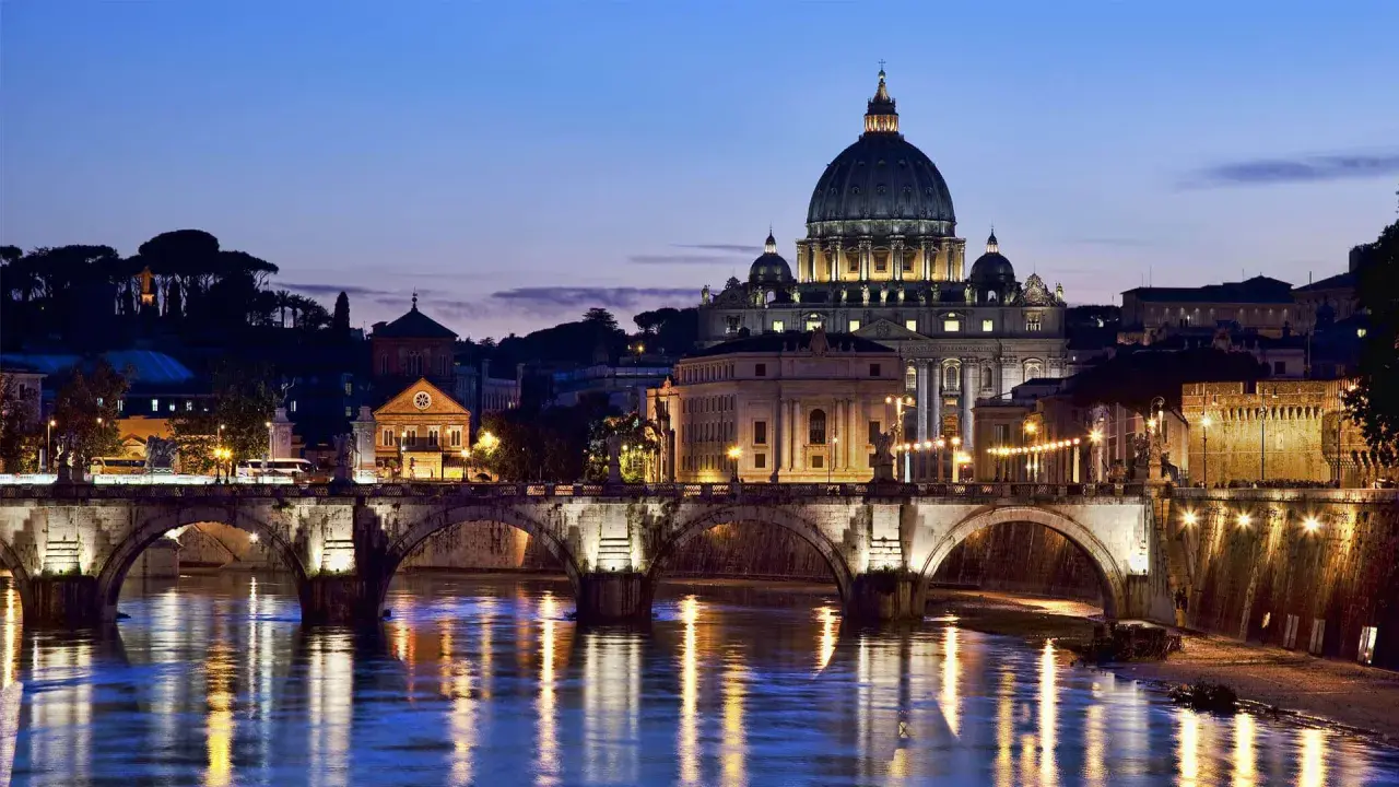 Un suggestivo ponte a Roma illumina il Tevere al crepuscolo, con San Pietro sullo sfondo.