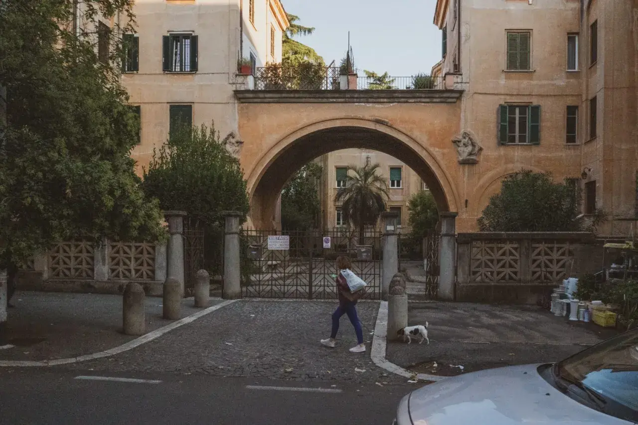 Una ragazza attraversa un arco a Montesacro, Roma. Scopri come arrivare in questo quartiere caratteristico.