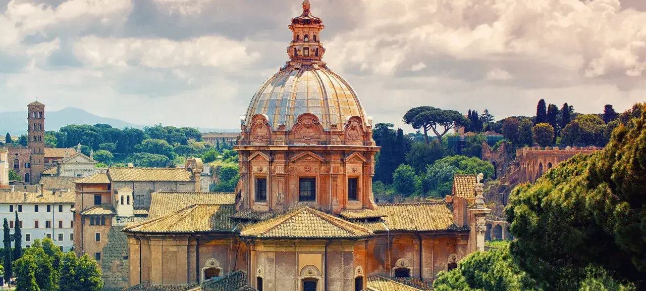 Cupola della chiesa dei Santi Luca e Martina a Roma, con tetti e alberi circostanti sotto un cielo nuvoloso.