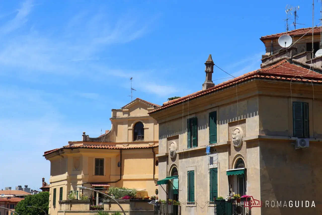 Edifici storici con tetti rossi e finestre verdi a Garbatella, un quartiere romano da scoprire.