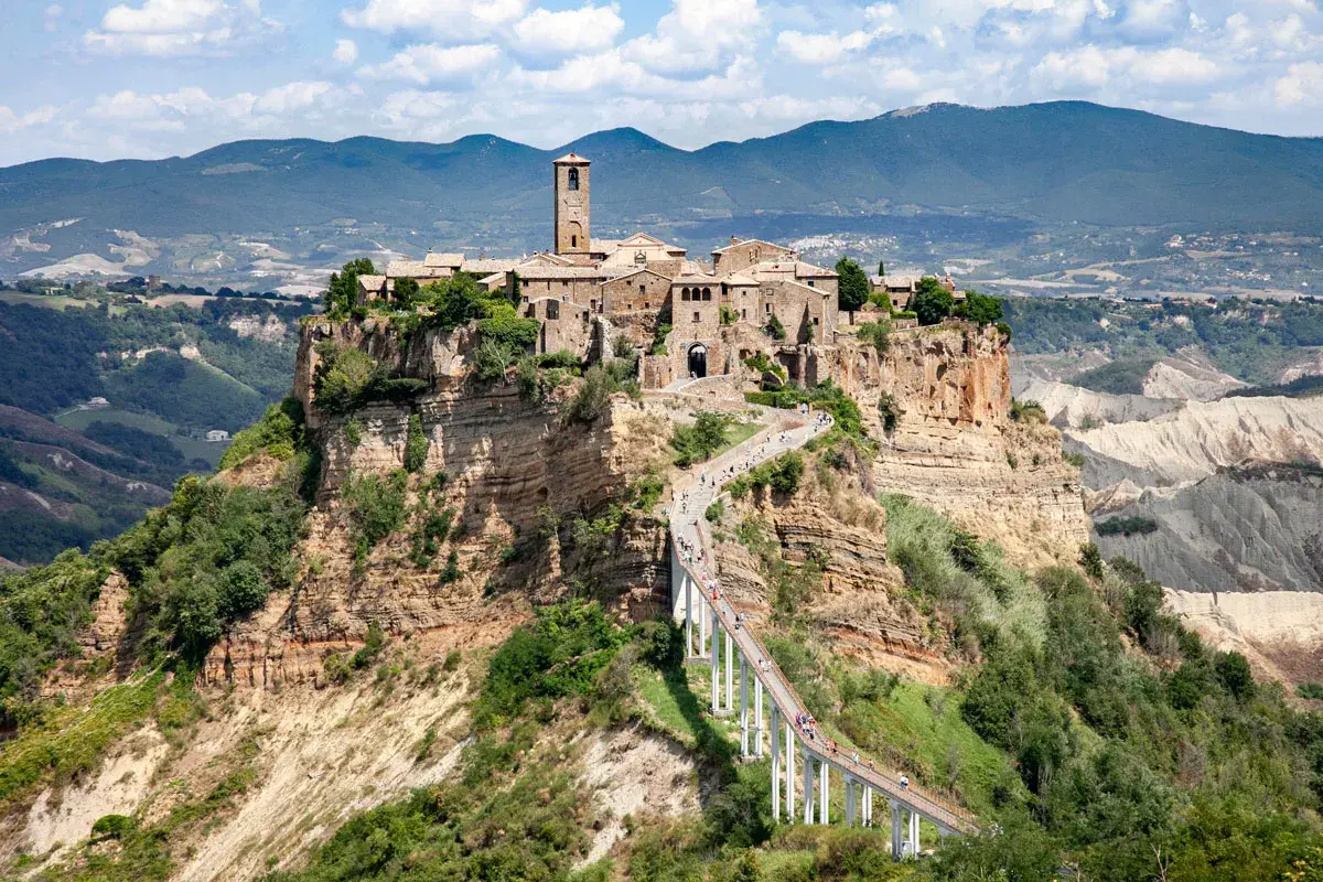 Civita di Bagnoregio, un borgo arroccato su una rupe, si trova in provincia di Viterbo. La sua bellezza è unica, raggiungibile solo tramite un lungo ponte pedonale.