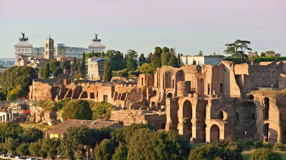 Rovine antiche a Roma, con il Vittoriano sullo sfondo. Immagina le corse dei carri nel **Circo Massimo**.