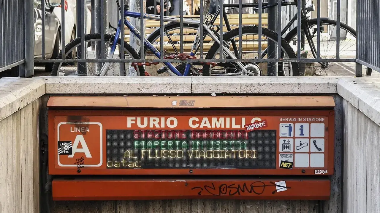 Segnale luminoso alla fermata Furio Camillo, Linea A. Biciclette parcheggiate dietro una ringhiera.