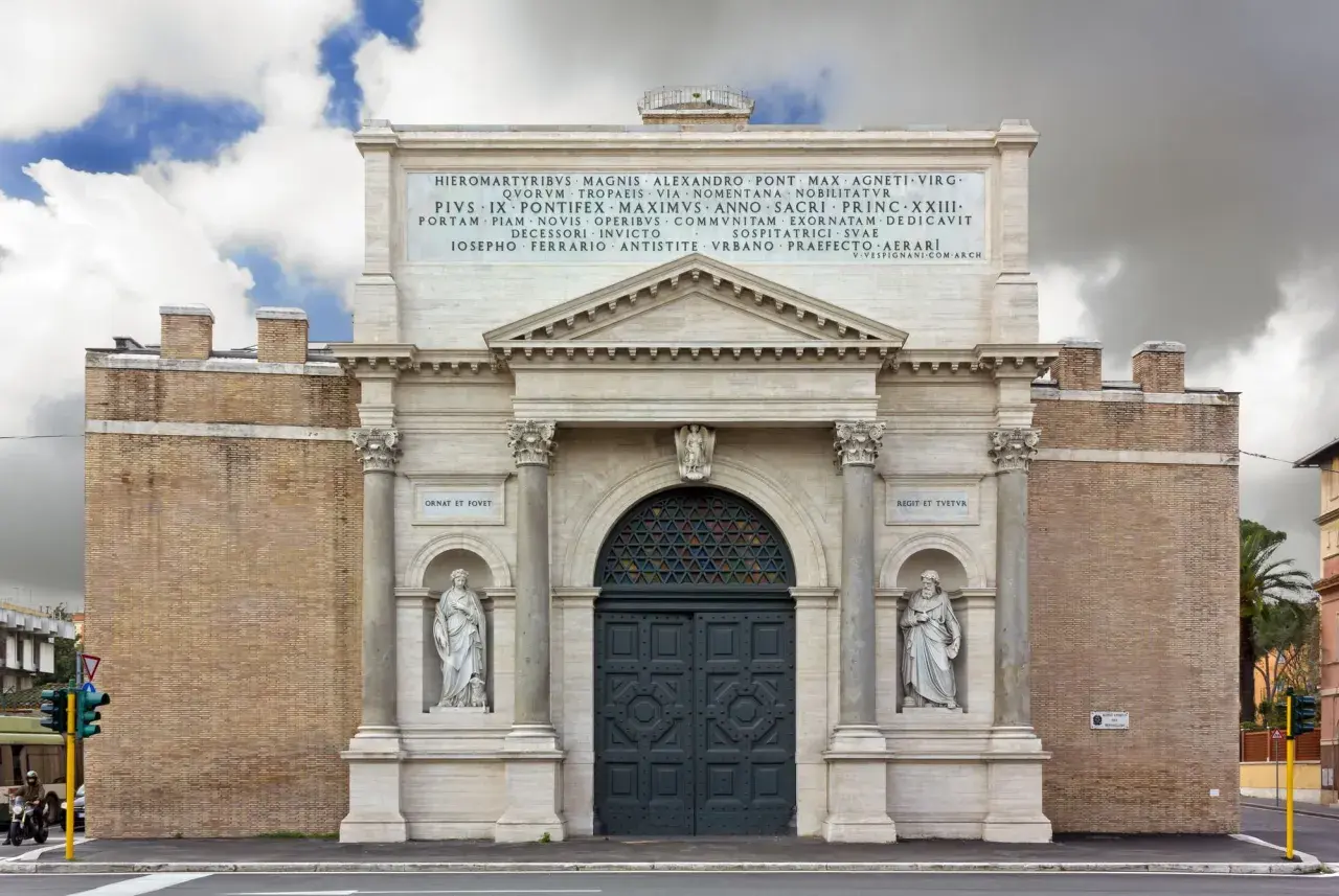 La Porta Pia, con le sue statue e iscrizioni, si erge maestosa sotto un cielo nuvoloso.