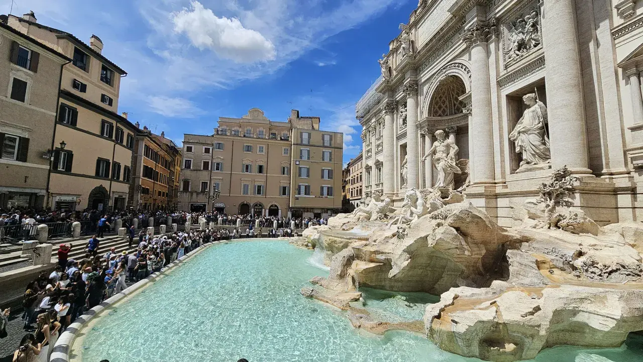Fontana di Trevi, una delle più celebri fontane di Roma, con una folla di turisti che ammirano la sua maestosità.