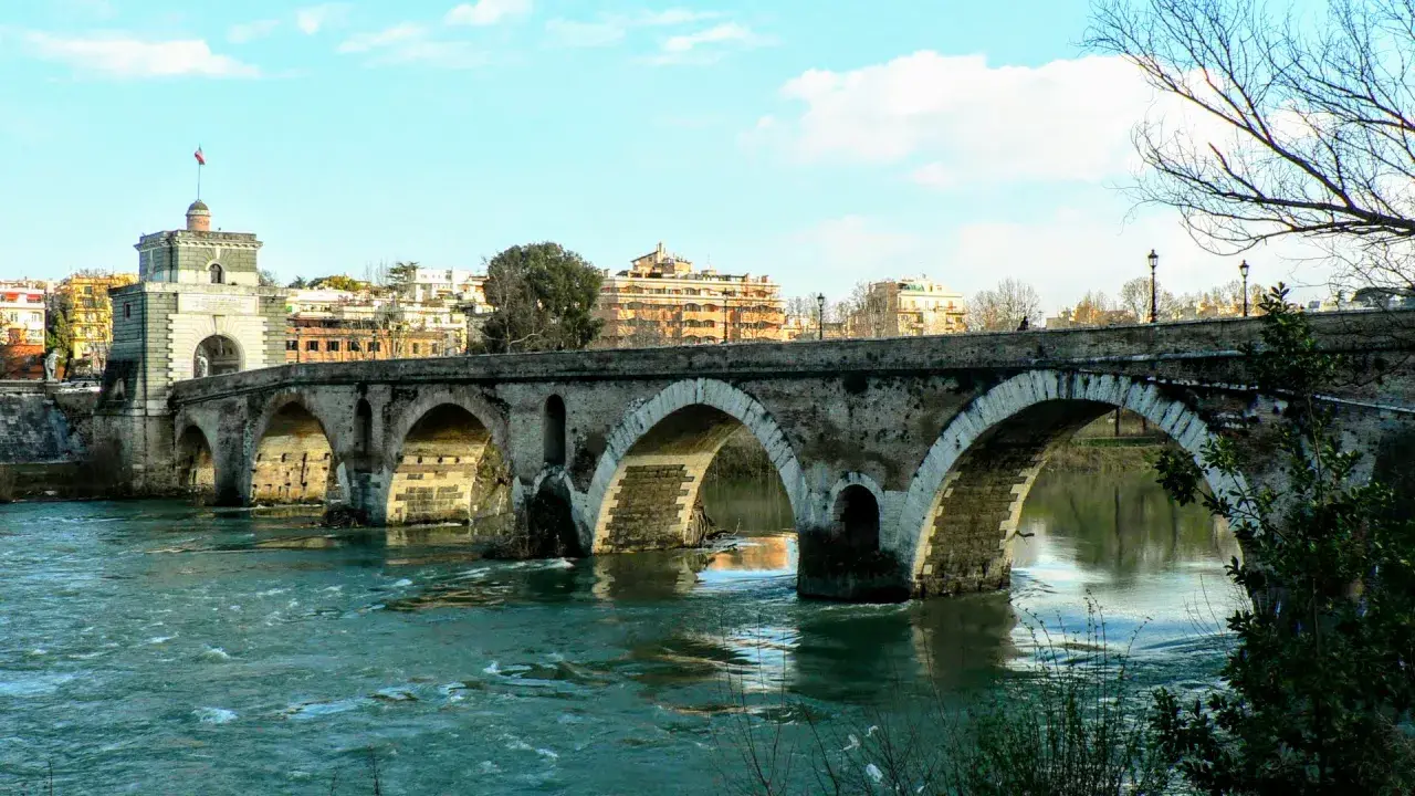 Ponte Sisto attraversa il fiume Tevere, collegando il centro storico con Trastevere. Le sue arcate di pietra riflettono sull'acqua.