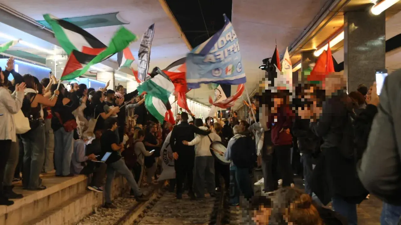 Folla in piazza a Roma per uno sciopero venerdì, sventolano bandiere palestinesi e altri vessilli.