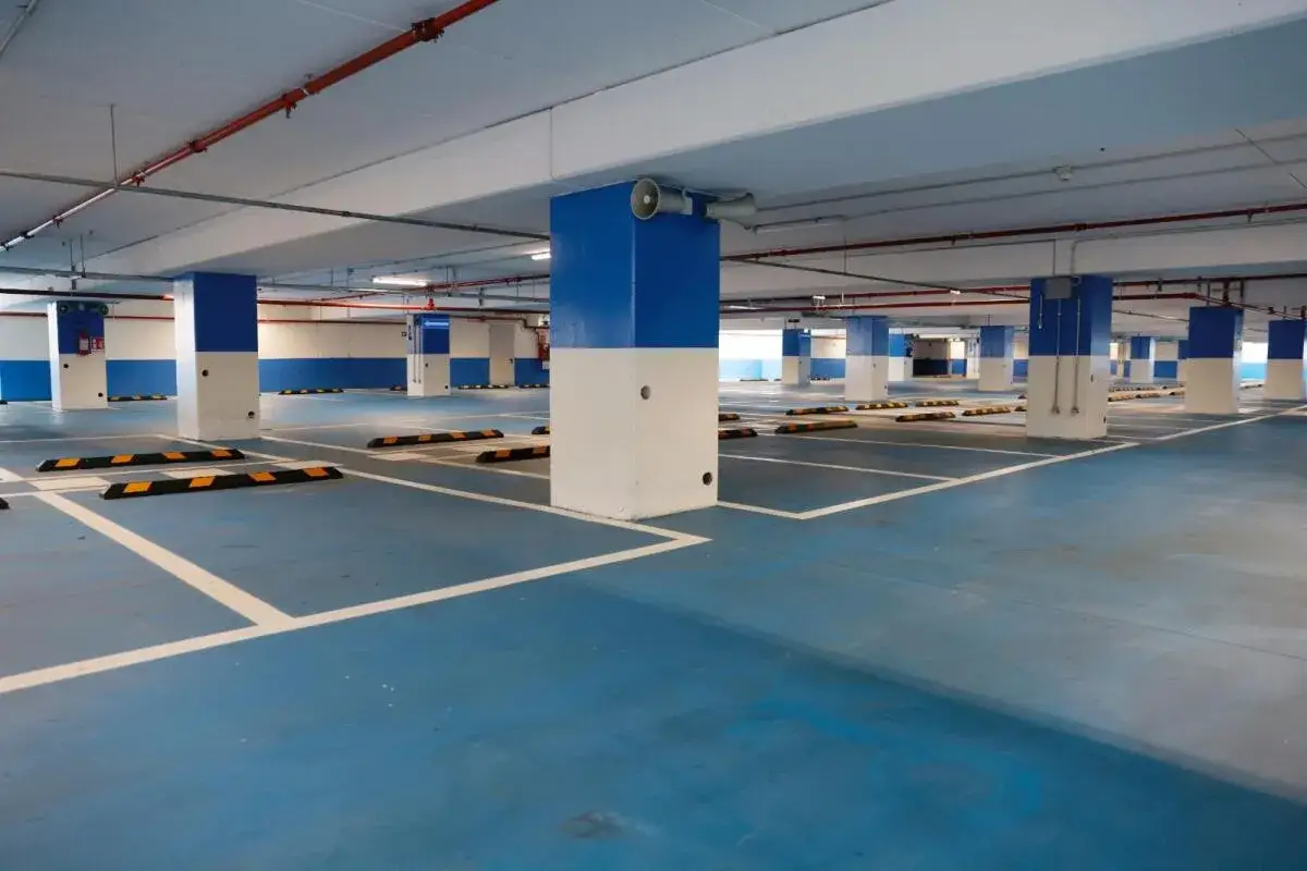 Parcheggio sotterraneo con pavimentazione blu, colonne bianche e blu, e segnaletica per la fermata metro Annibaliano.