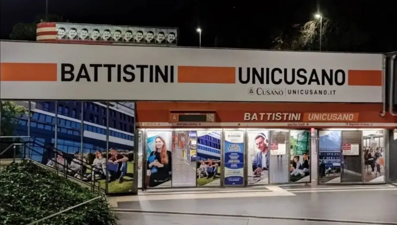 Ingresso della metro Battistini a Roma, con insegne UNICUSANO e immagini di studenti.