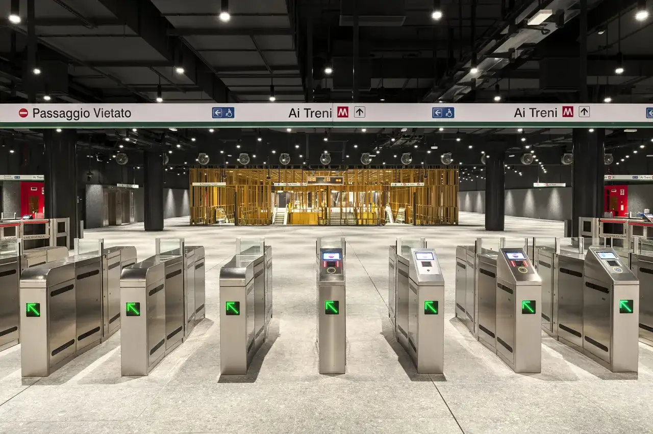 Ingresso moderno della metro Colosseo, linea B, con tornelli luminosi e segnaletica per i treni.