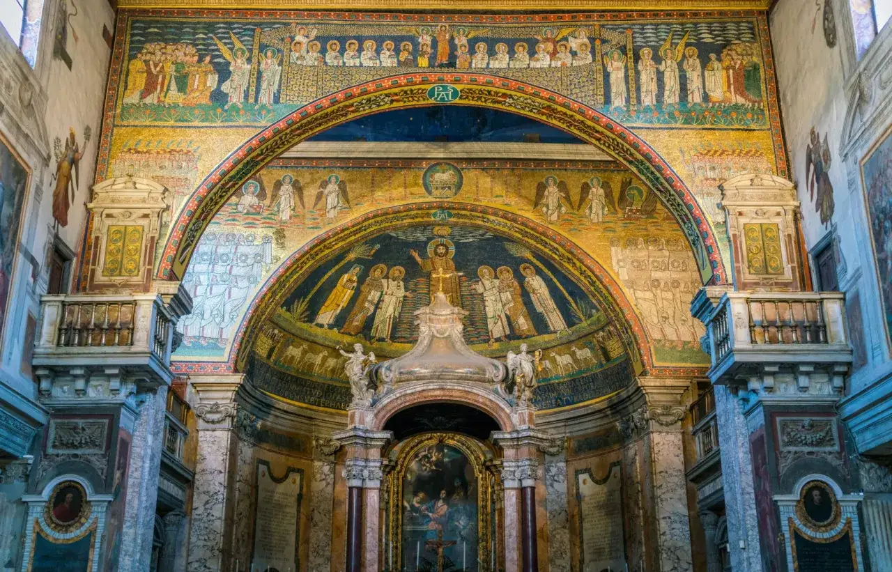 Mosaici dorati e colorati nella basilica dei Santi Cosma e Damiano, con Cristo al centro e figure sacre.