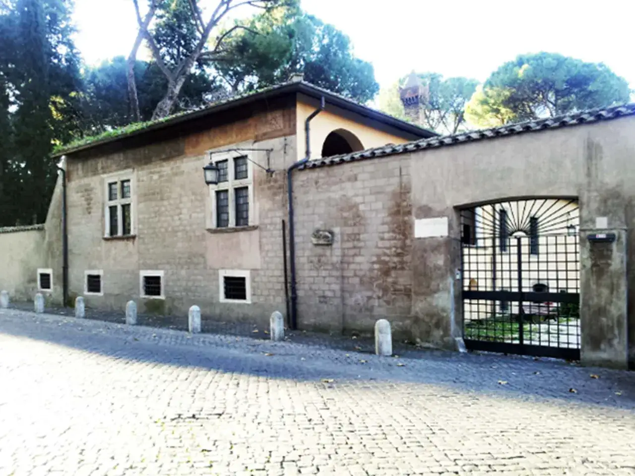 La casina cardinal Bessarione, con tetto verde e cancello in ferro battuto, si affaccia su una strada acciottolata.