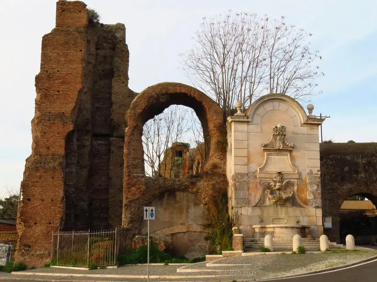Antica porta furba metro, con rovine romane e una fontana barocca.