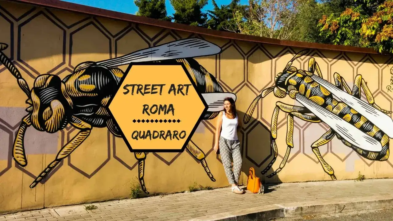 Ragazza posa accanto a un murale di vespe giganti, un'opera di street art a Roma Quadraro.