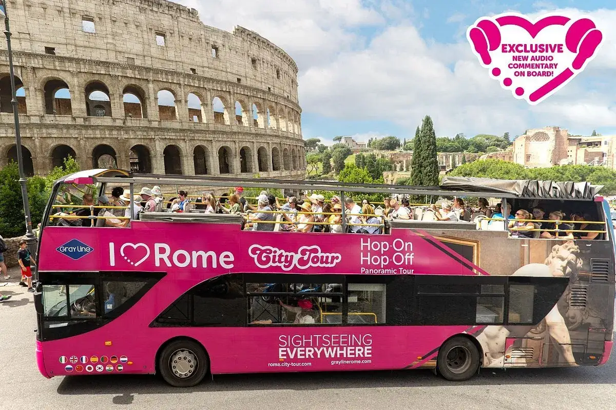 Autobus turistico rosa con vista sul Colosseo. Scopri Roma come arrivare con il tour Hop-On Hop-Off.