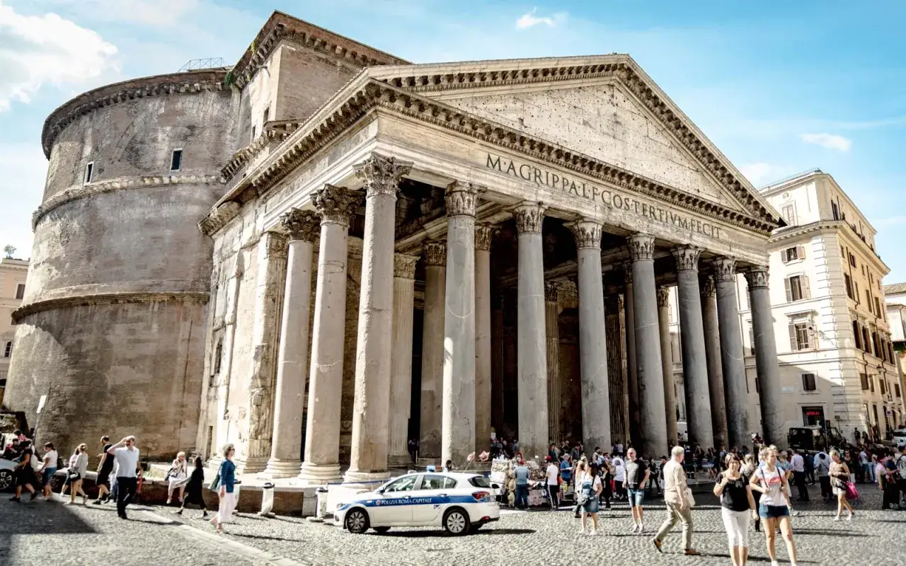 Il Pantheon, un must per chi cerca cosa vedere a Roma a piedi. Turisti e auto della polizia animano la piazza antistante.