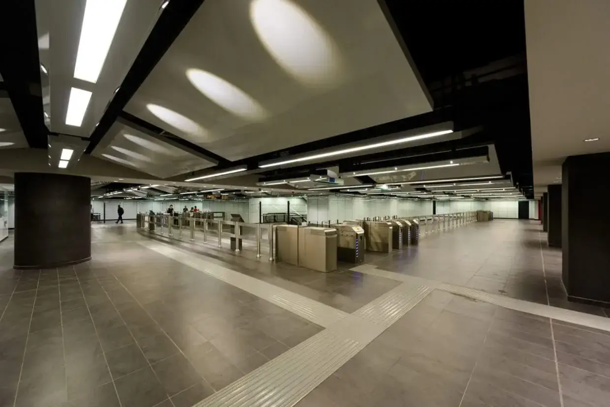 Ingresso moderno della metro Mirti con tornelli automatici e illuminazione a soffitto.