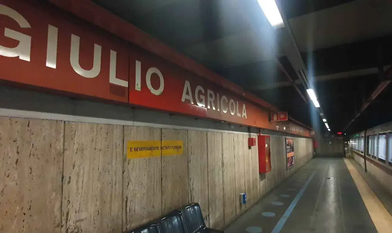 La fermata Giulio Agricola della metropolitana di Roma, con insegna rossa e pareti in travertino.