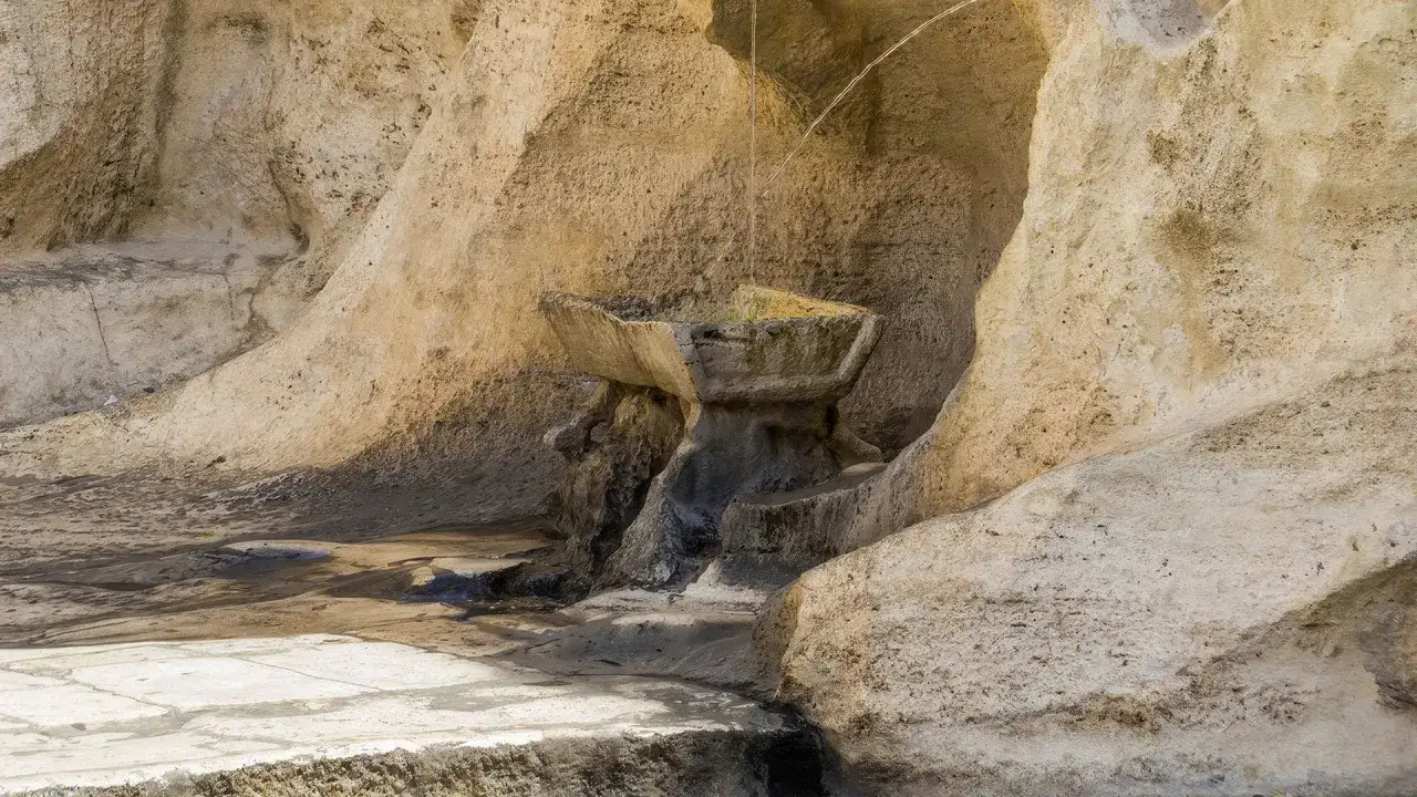 Antica fontana degli innamorati a Roma, scolpita nella roccia, con acqua che scorre.